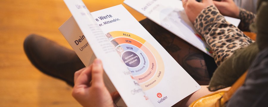 Eine Frau blättert in der Werte-Broschüre.