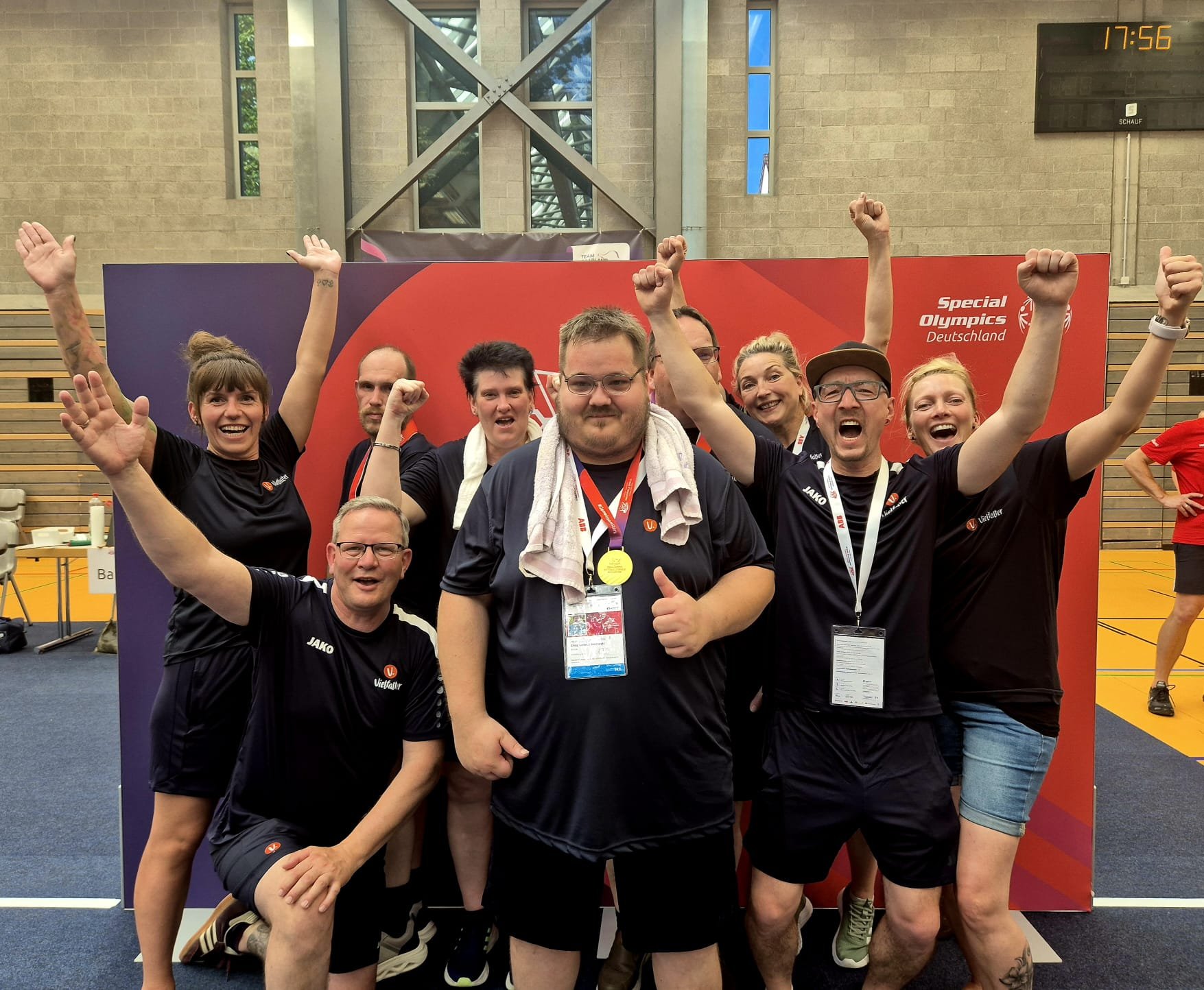 Ein Sportlerteam steht jubelnd in einer Turnhalle