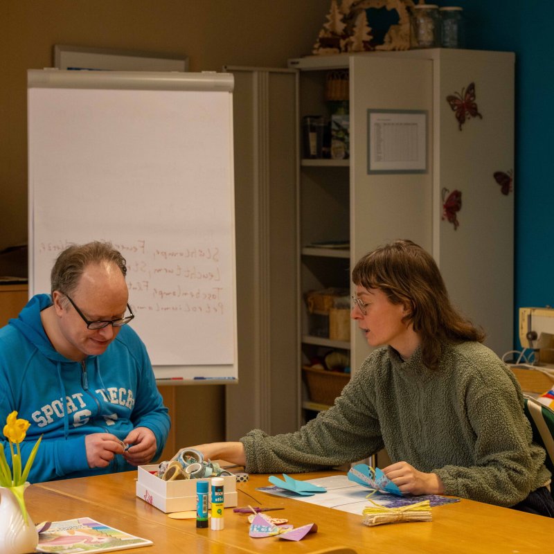 Mann und Frau sitzen am Tisch und basteln