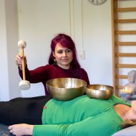 Eine junge Frau bei einer Klangschalentherapie.