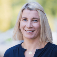 Nahaufnahme einer blonden Frau mit unscharfen grünem Hintergrund