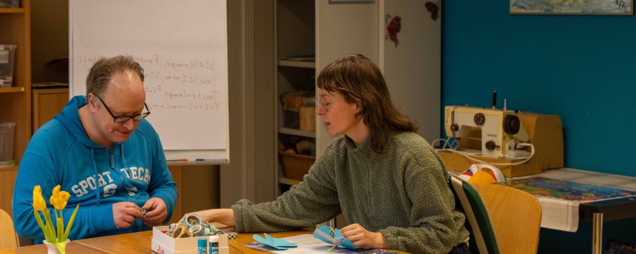 Mann und Frau sitzen am Tisch und basteln