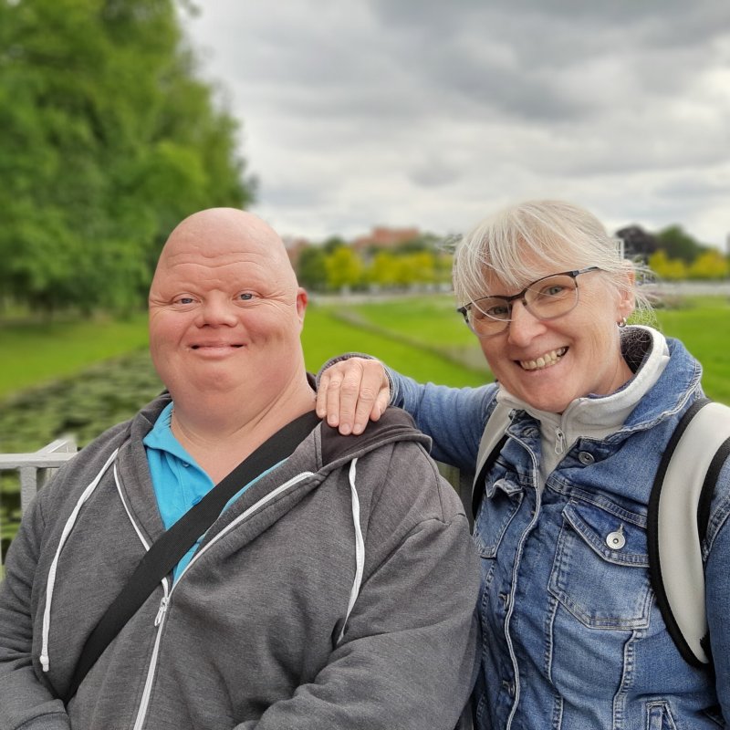Ein Mann und eine Frau stehen im Schlossgarten und lächeln in die Kamera.