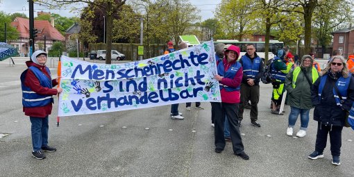 Menschen auf einer Demo halten ein Banner hoch