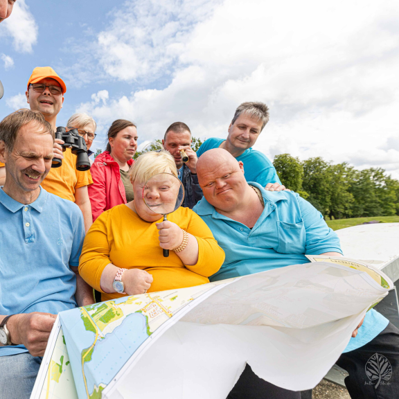 Eine Gruppe von Menschen  mit Unterstützungsbedarf schaut sich einen Stadtplan an.