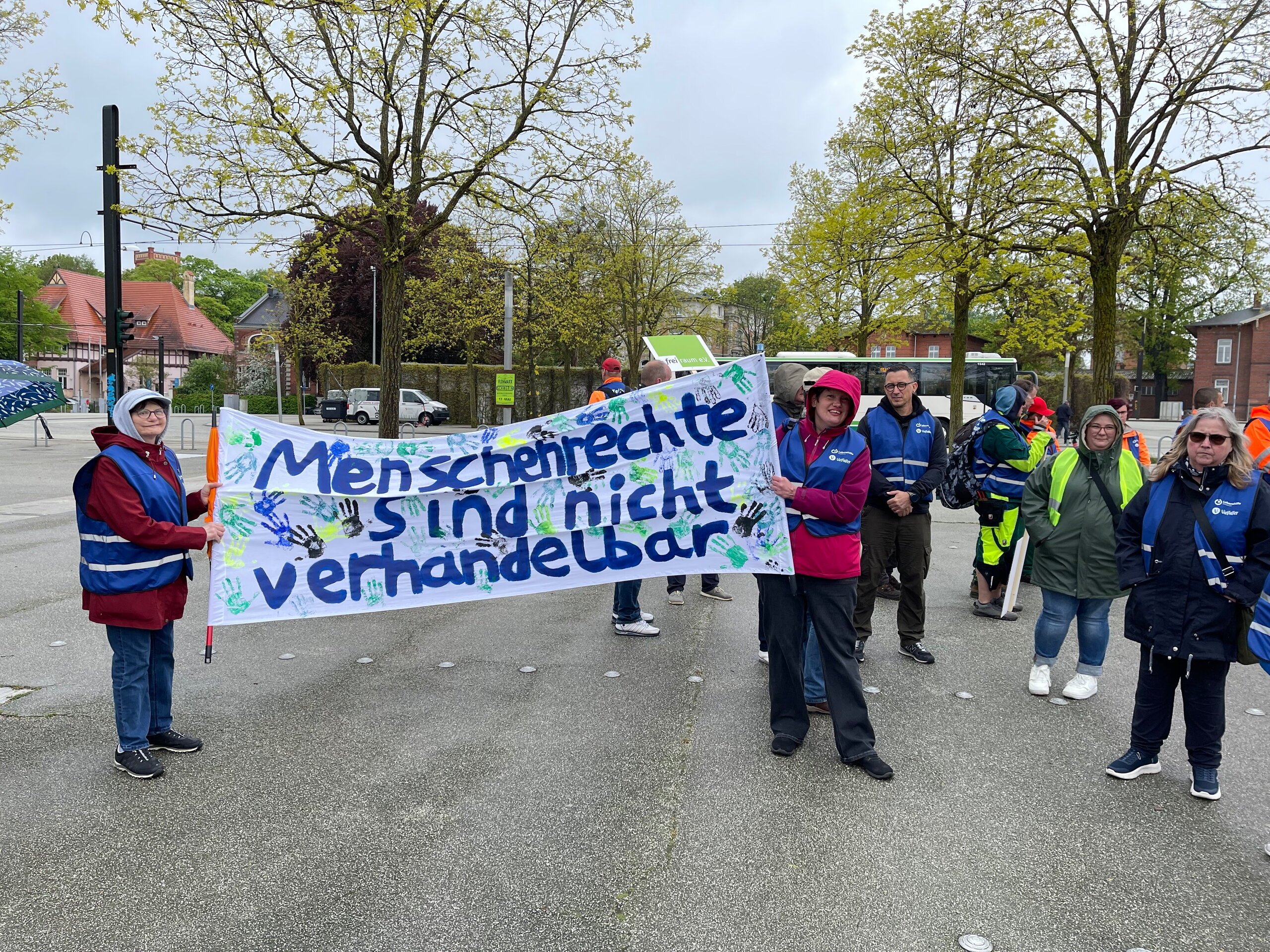 Menschen auf einer Demo halten ein Banner hoch