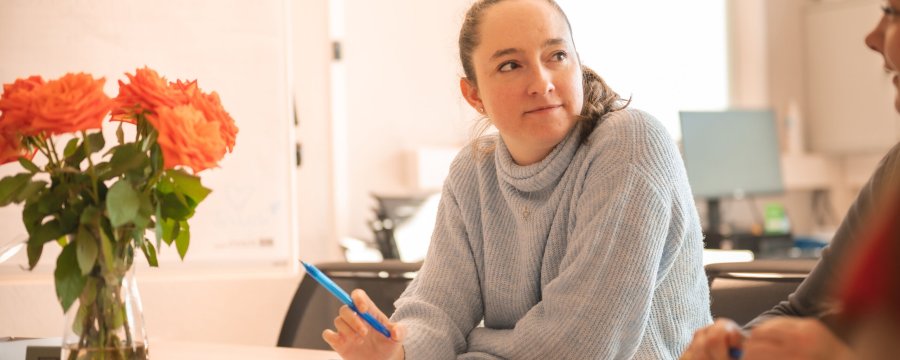 Zwei Frauen machen sich im gemeinsamen Gespräch Notizen.