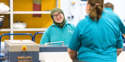 Zwei Frauen stehen in der Wäscherei und unterhalten sich freundlich