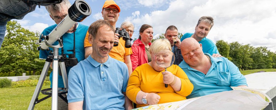 Eine Gruppe von Menschen  mit Unterstützungsbedarf schaut sich einen Stadtplan an.