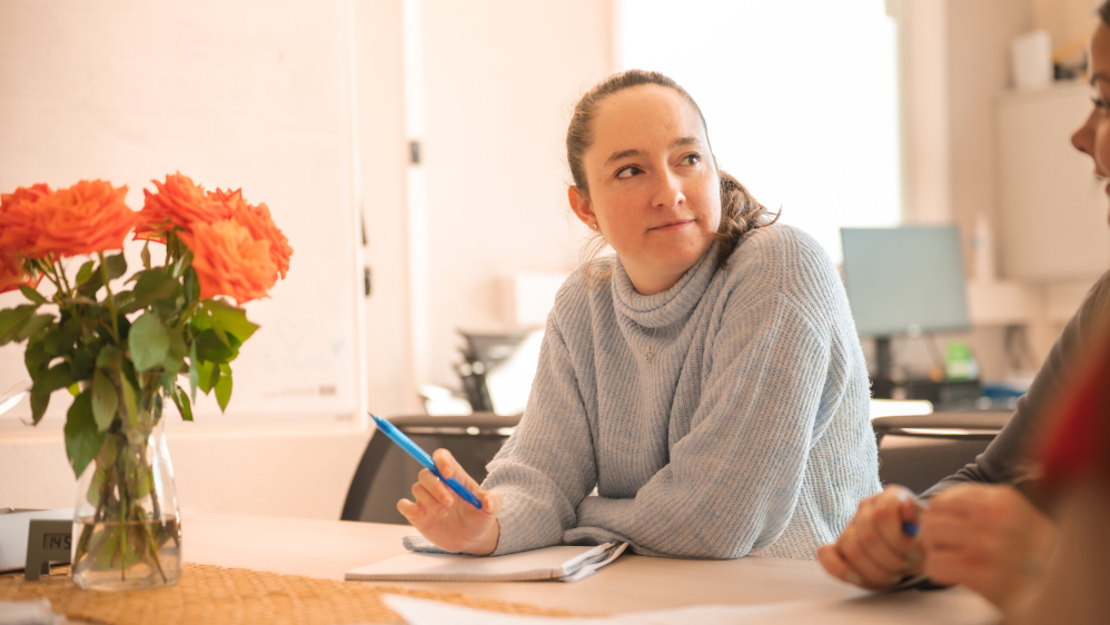 Zwei Frauen machen sich im gemeinsamen Gespräch Notizen.